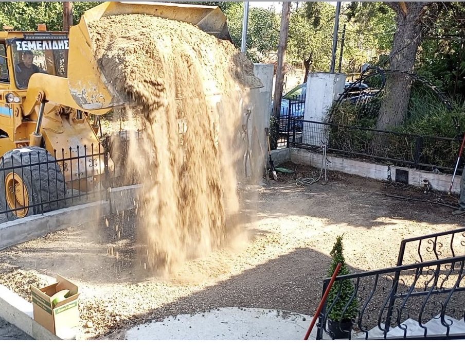 Φορτωτής ρίχνει νέο χώμα στην αυλή
